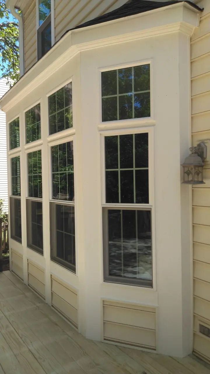 Side of the bay with tall windows and white trim.