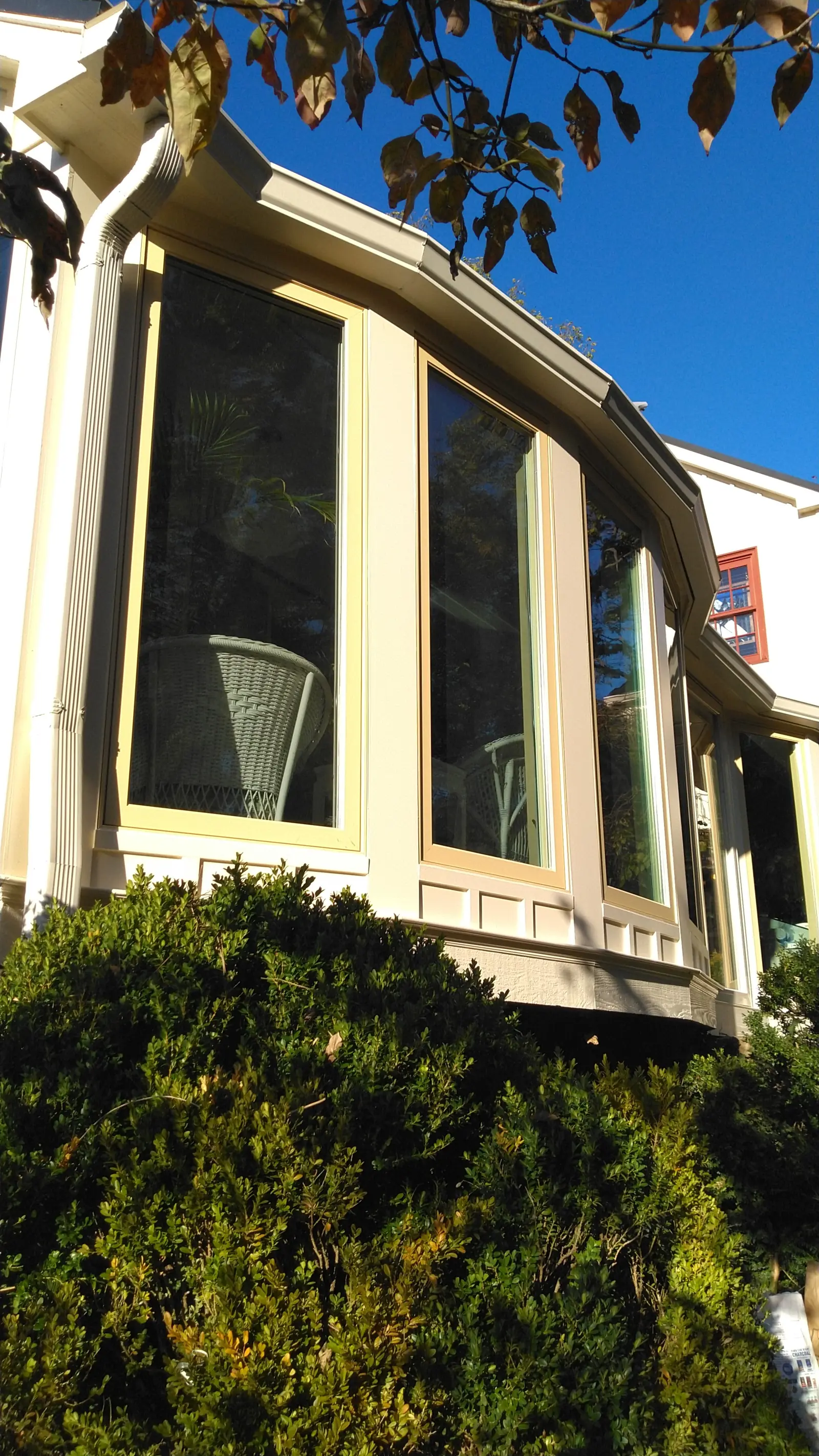 Side view of the curved window bank and the metal roof above it.