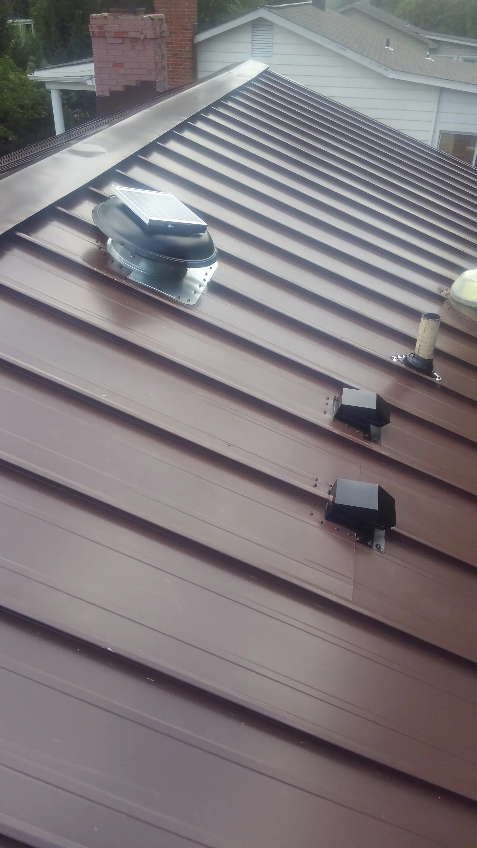 Brown standing seam panels with roof vents and boots.