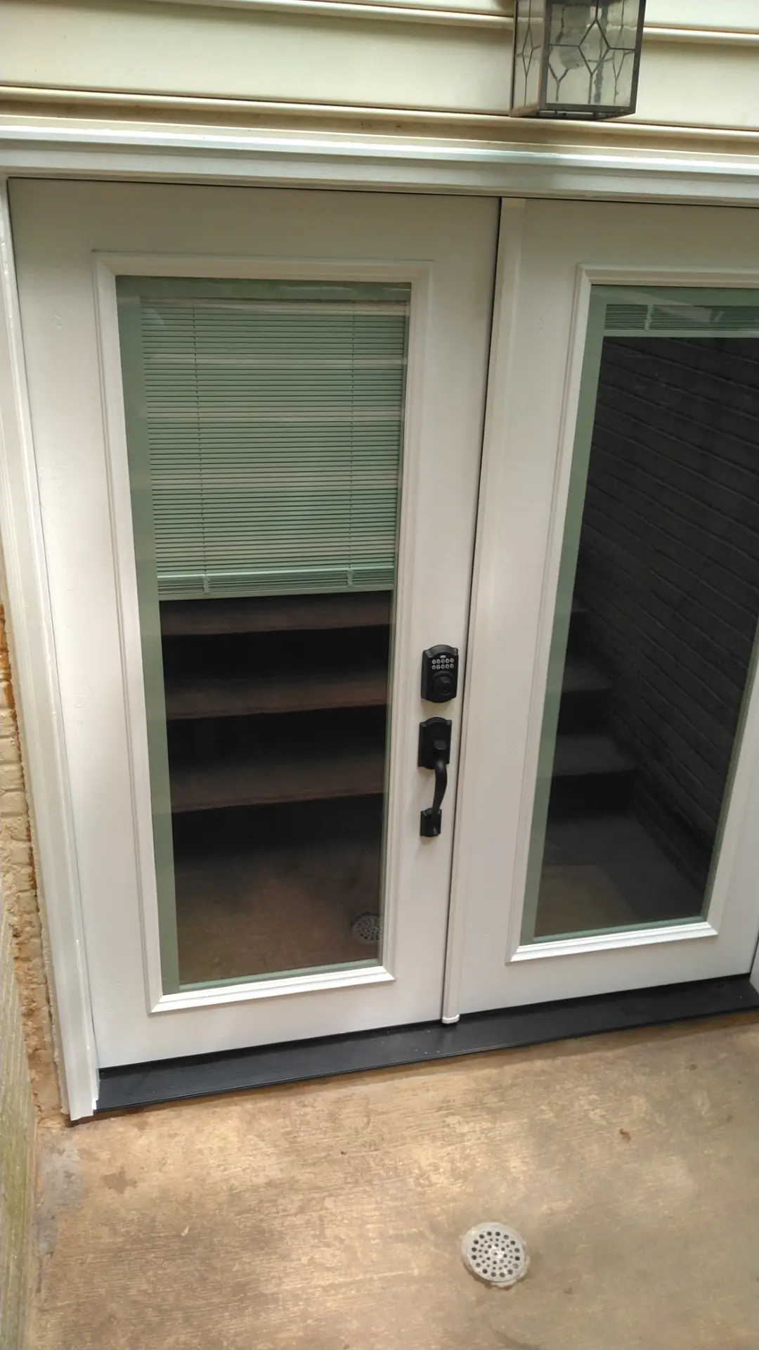 White glass French doors with a keypad lock opening onto a patio.