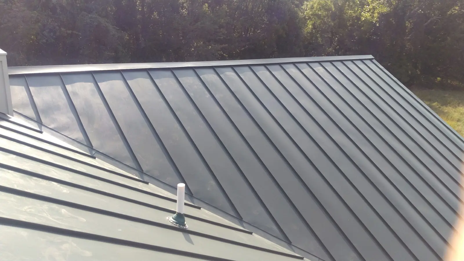 Dark green standing seam panels with a roof vent.