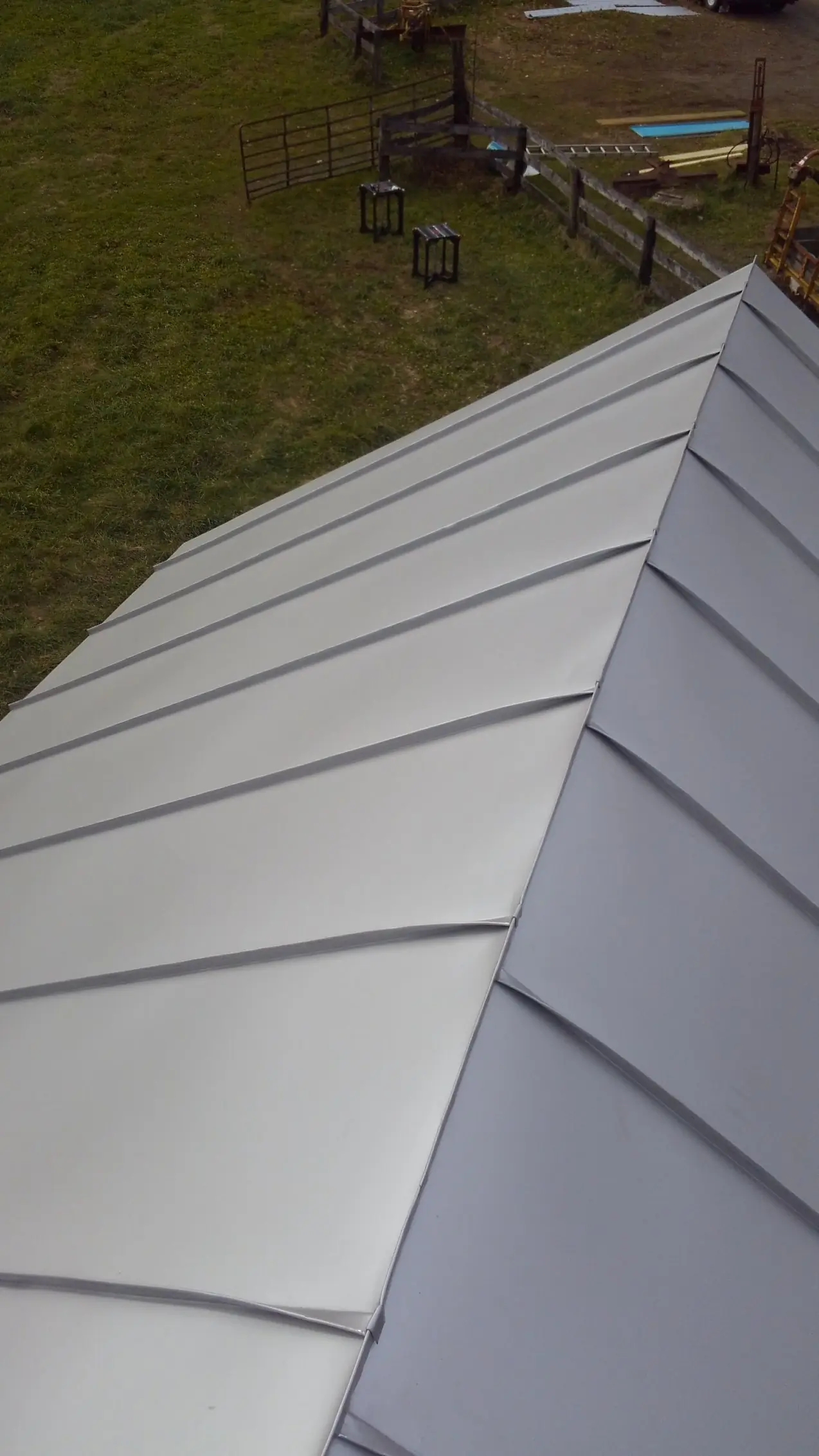 Light gray standing seam hip roof with a visible ridge.