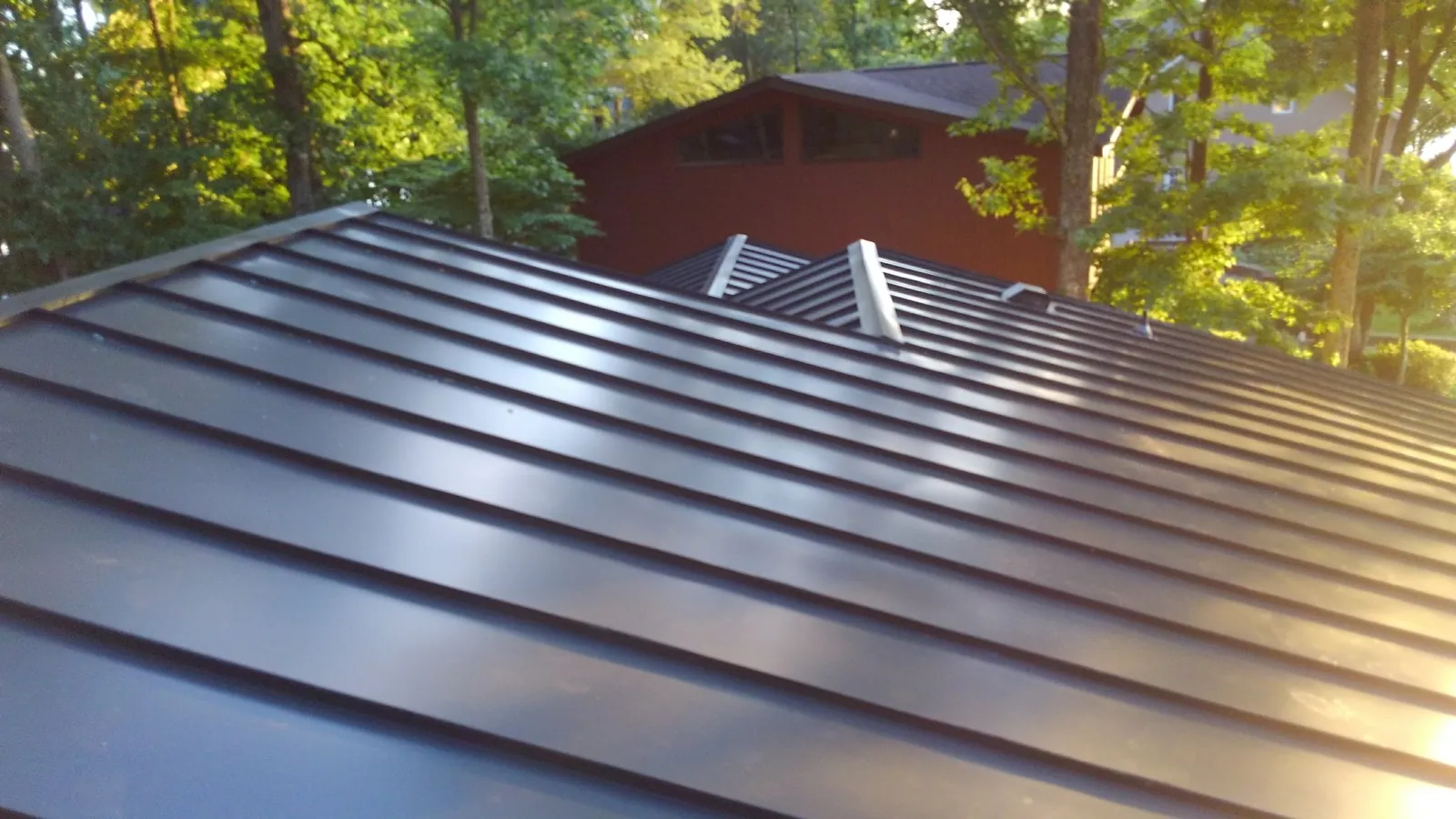 Close view of dark standing seam panels with crisp, even raised seams.