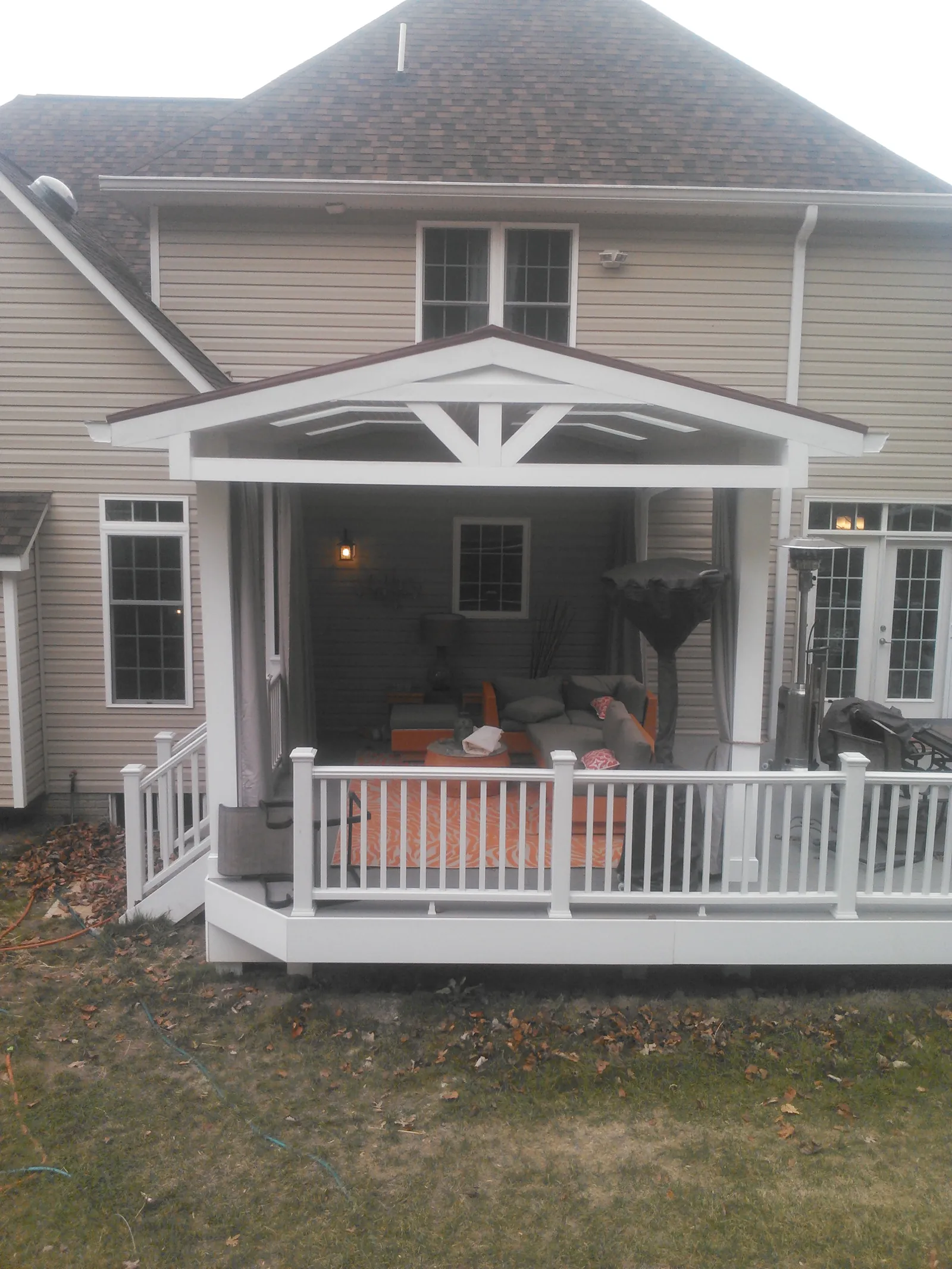 Covered rear porch with a gabled roof, skylights and white railings.