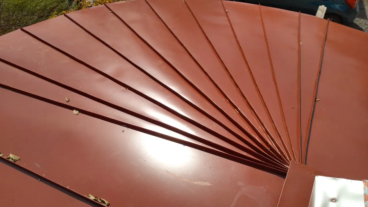 Closeup of the fan peak with red tapered panels meeting at the point.