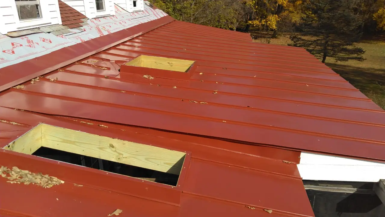 Red standing seam panels with two framed skylight openings.