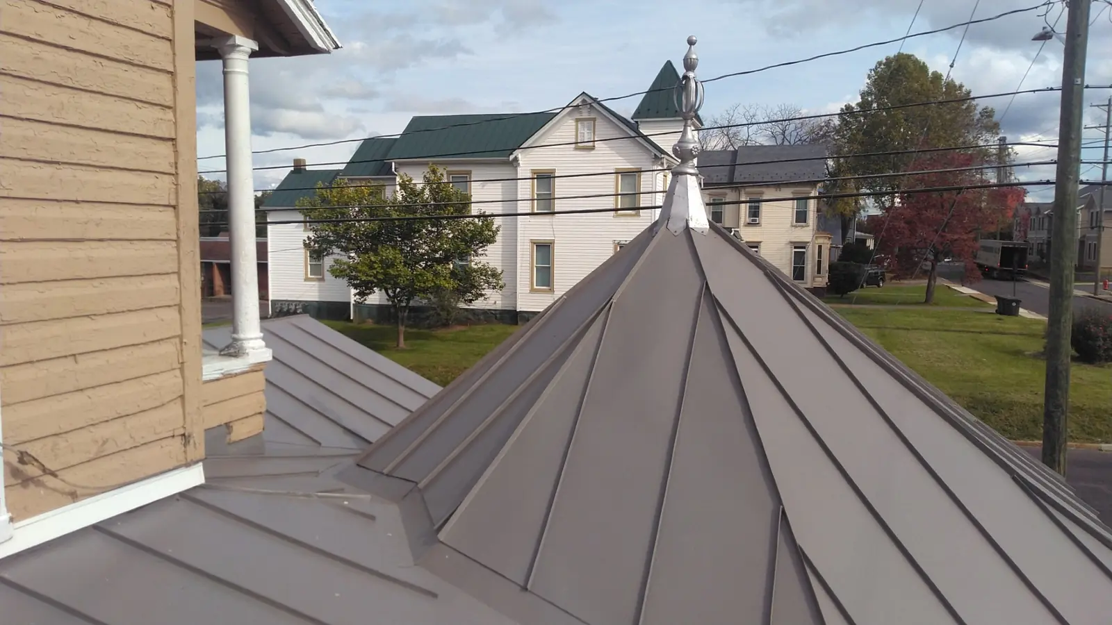 Slate gray standing seam gazebo roof with a finial and seams radiating from the peak.