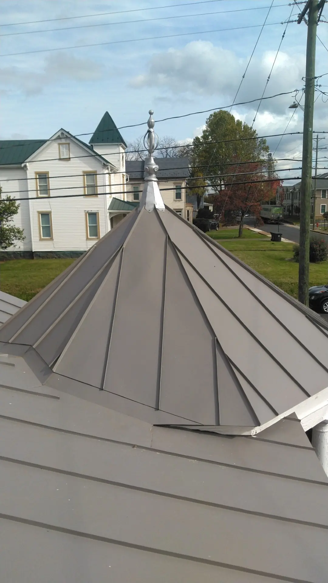 Slate gray standing seam with a finial against the town street.