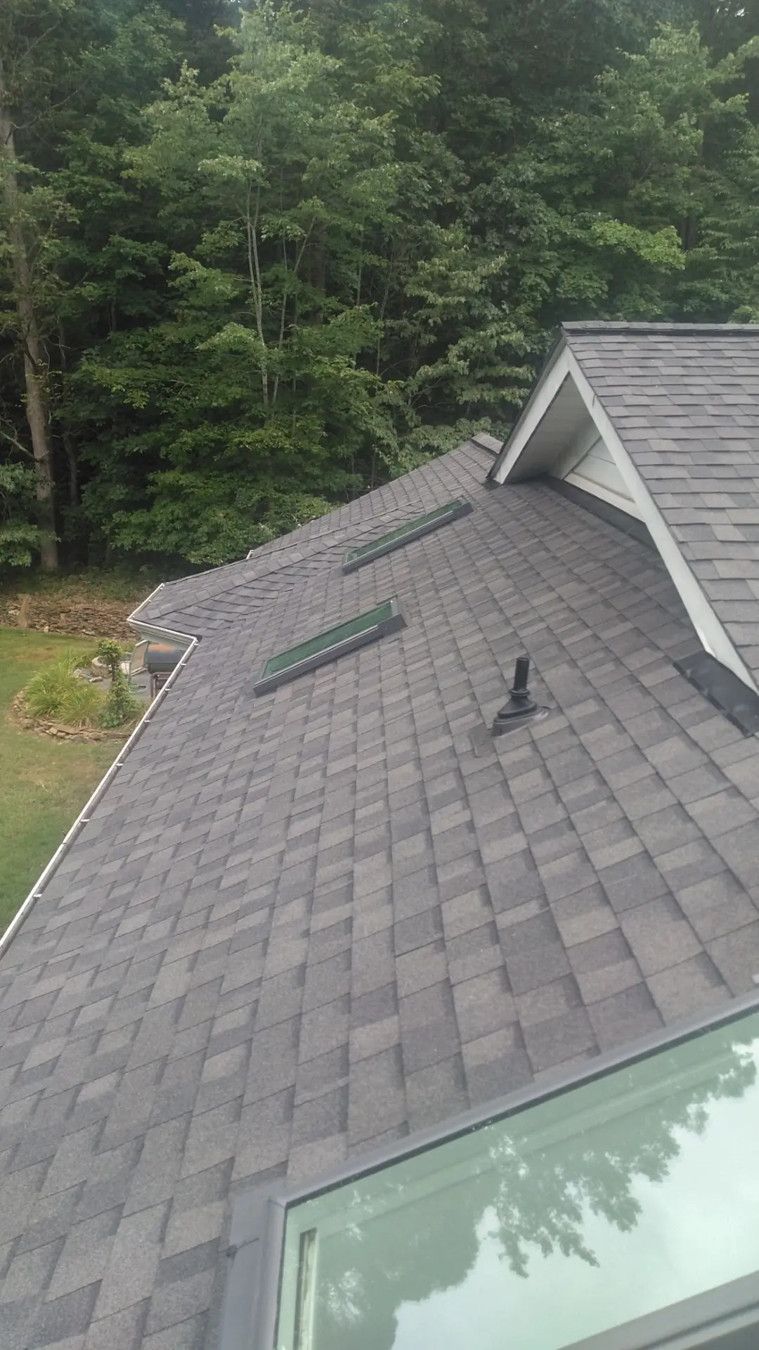 Pewterwood shingles beside a skylight at the roof edge.